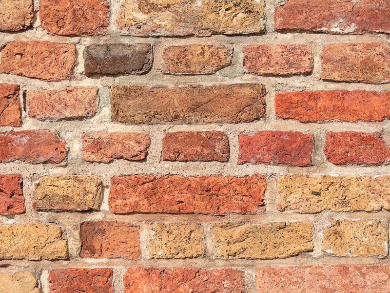 Mur en briques anciennes, gros plan sur les joints de mortier.