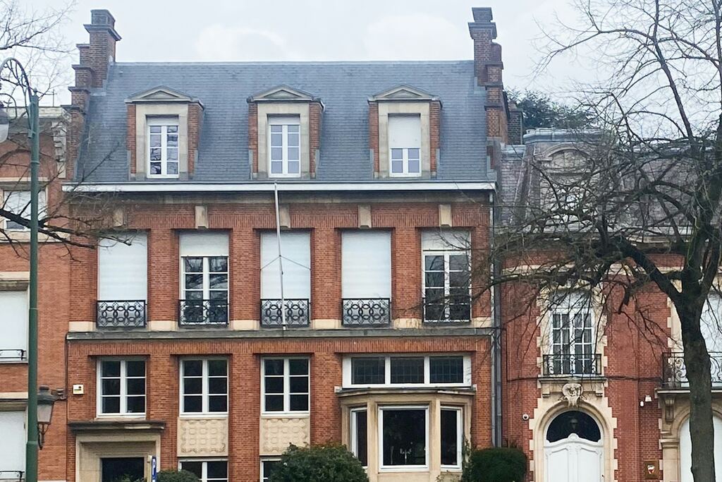 Maison bruxelloise en briques rouges, toit en ardoises et lucarnes.
